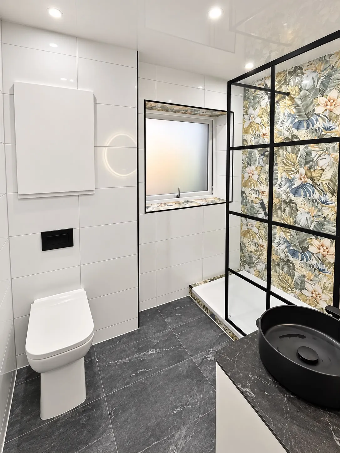 Same bathroom after: walk-in shower with black framed screen, floral feature wall and black basin