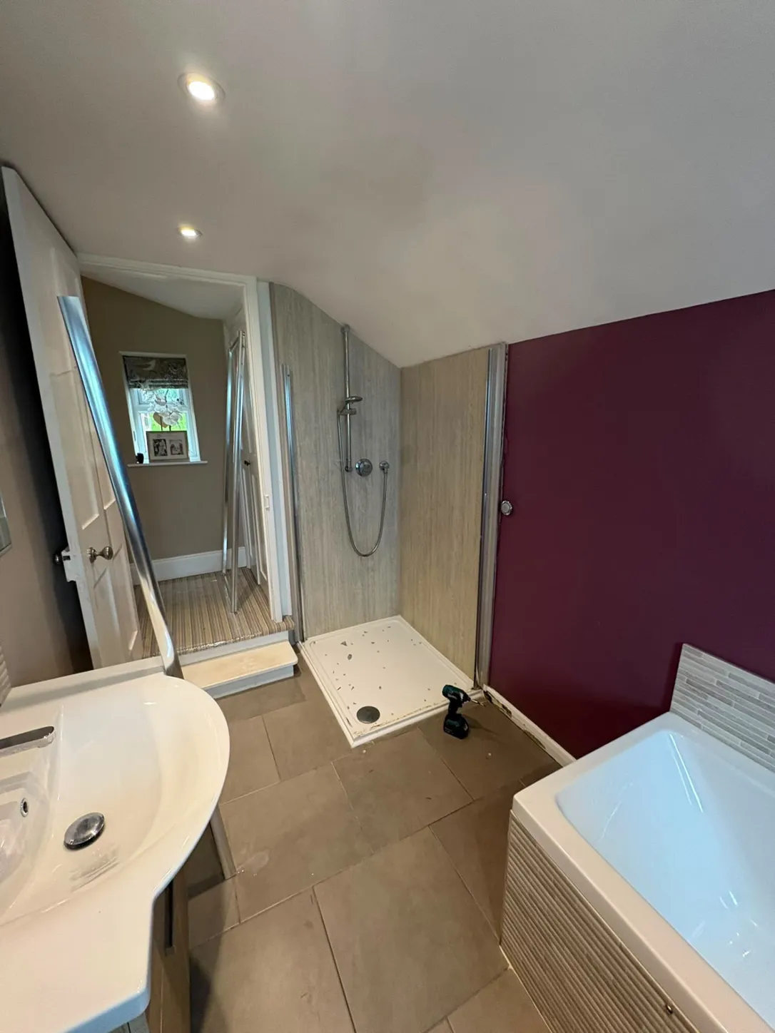 Bathroom before: plum feature wall, old shower enclosure and grey floor tiles